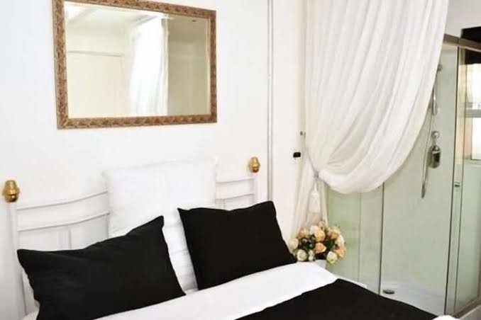 A double room with gold-framed mirror and shower en-suite
