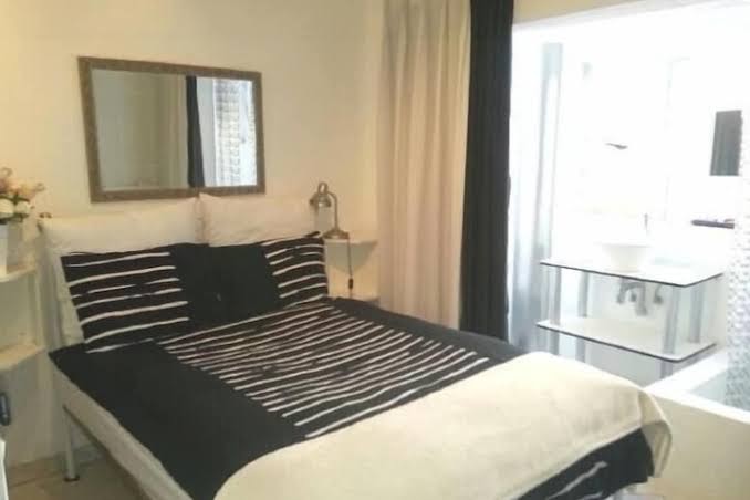 A double room with striped linen and bedside basin